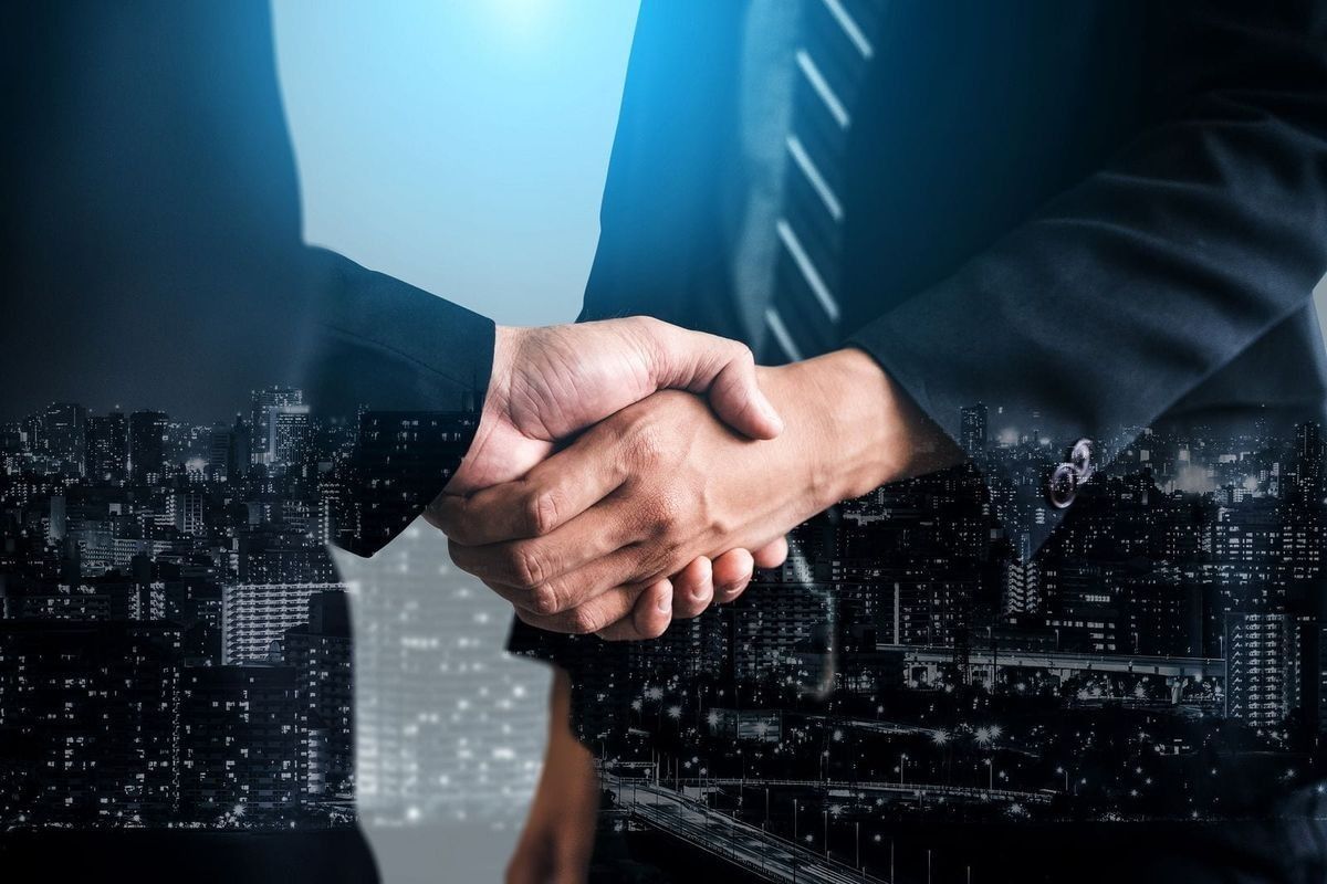 Business professionals shaking hands with city skyline background